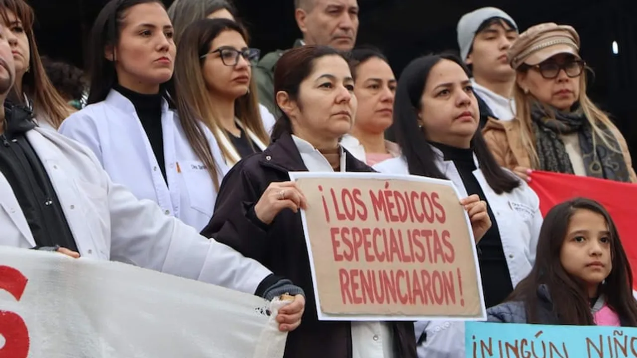 Médicos con batas blancas protestan; una mujer sostiene un cartel que dice '¡Los médicos especialistas renunciaron!'.