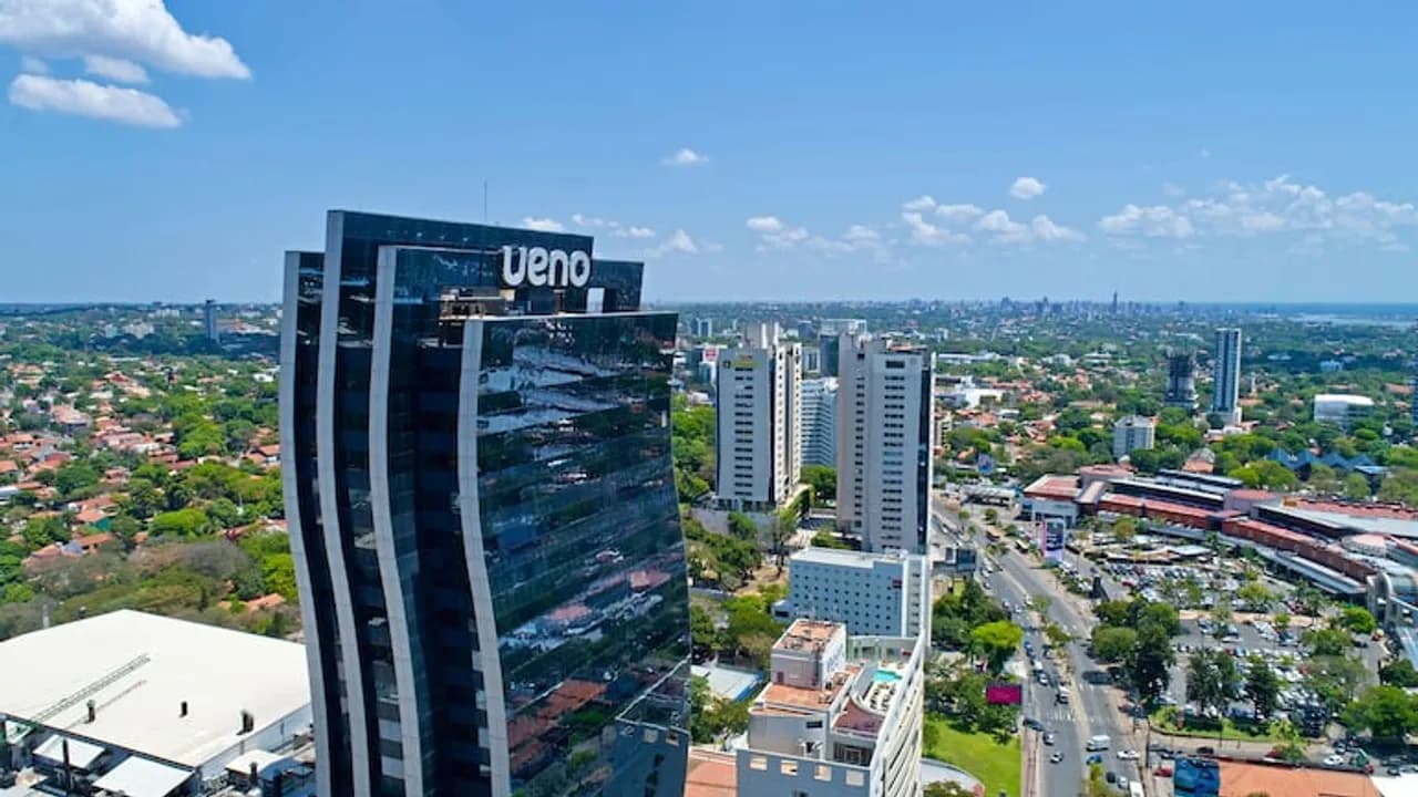 Vista aérea del edificio corporativo de Ueno en Asunción bajo un cielo despejado.