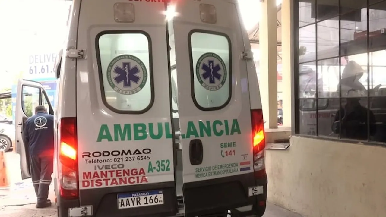 Parte trasera de una ambulancia del SEME con las puertas abiertas frente a un edificio y un paramédico al lado.