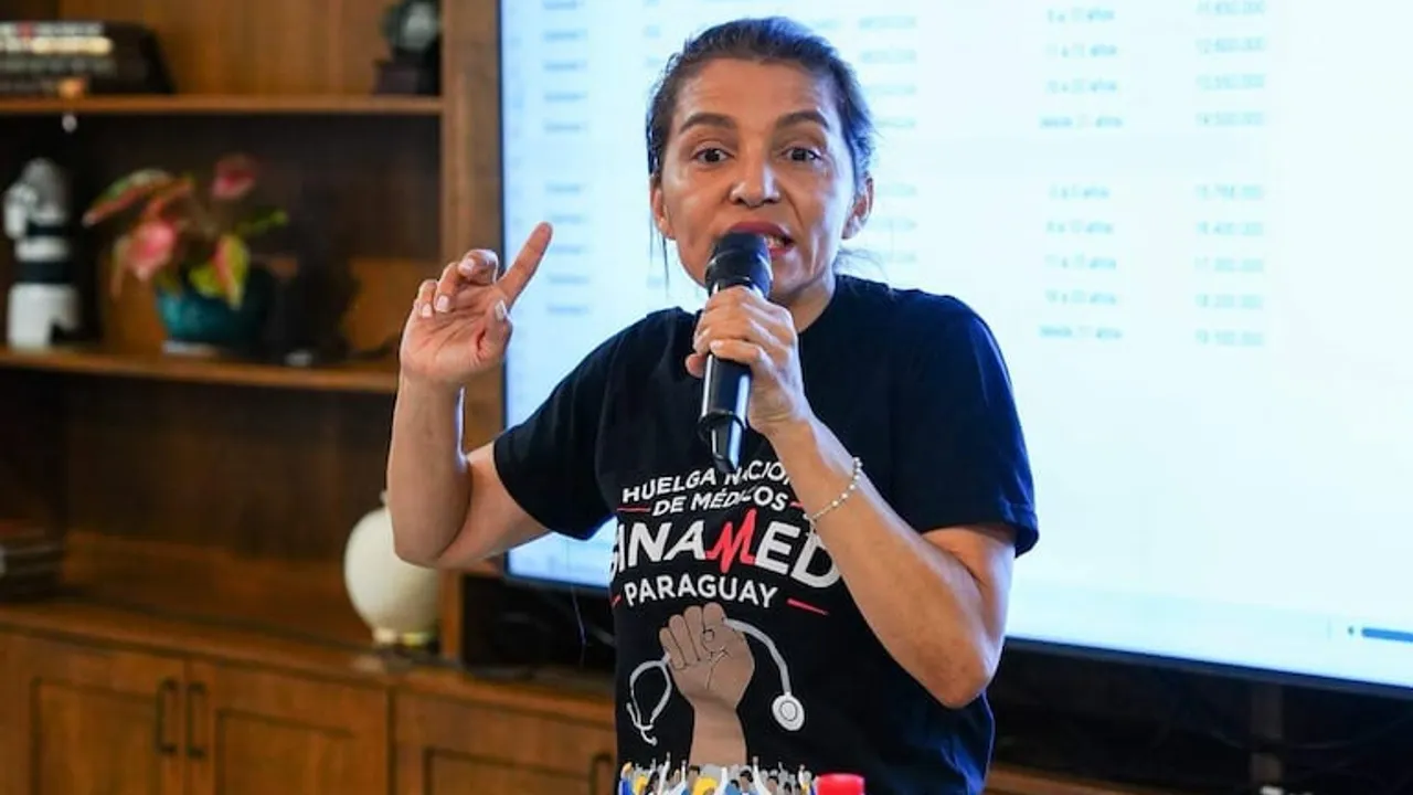 Rossana González habla con un micrófono vistiendo una remera negra del sindicato Sinamed Paraguay.