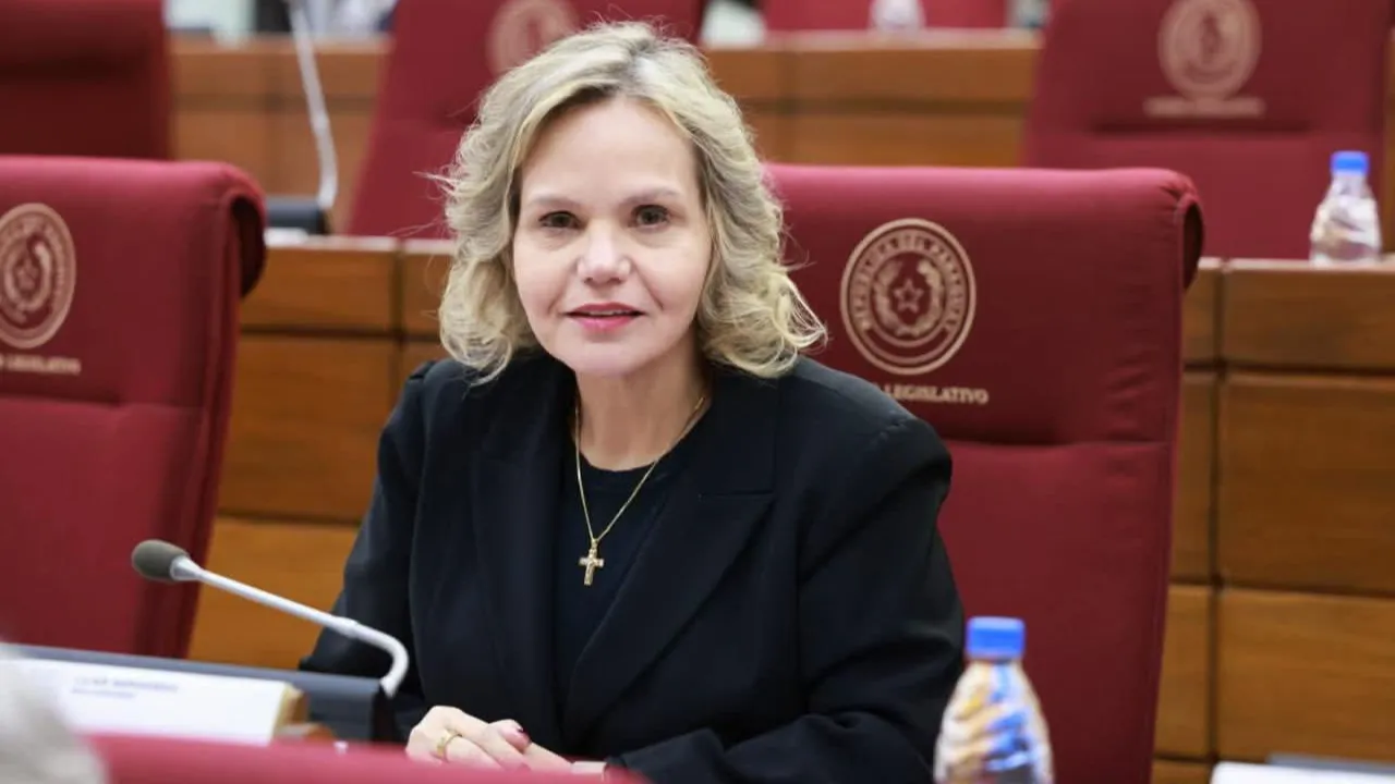 La senadora Lilian Samaniego sentada en su banca del Senado de Paraguay, vistiendo un saco negro y una cadena con cruz dorada.