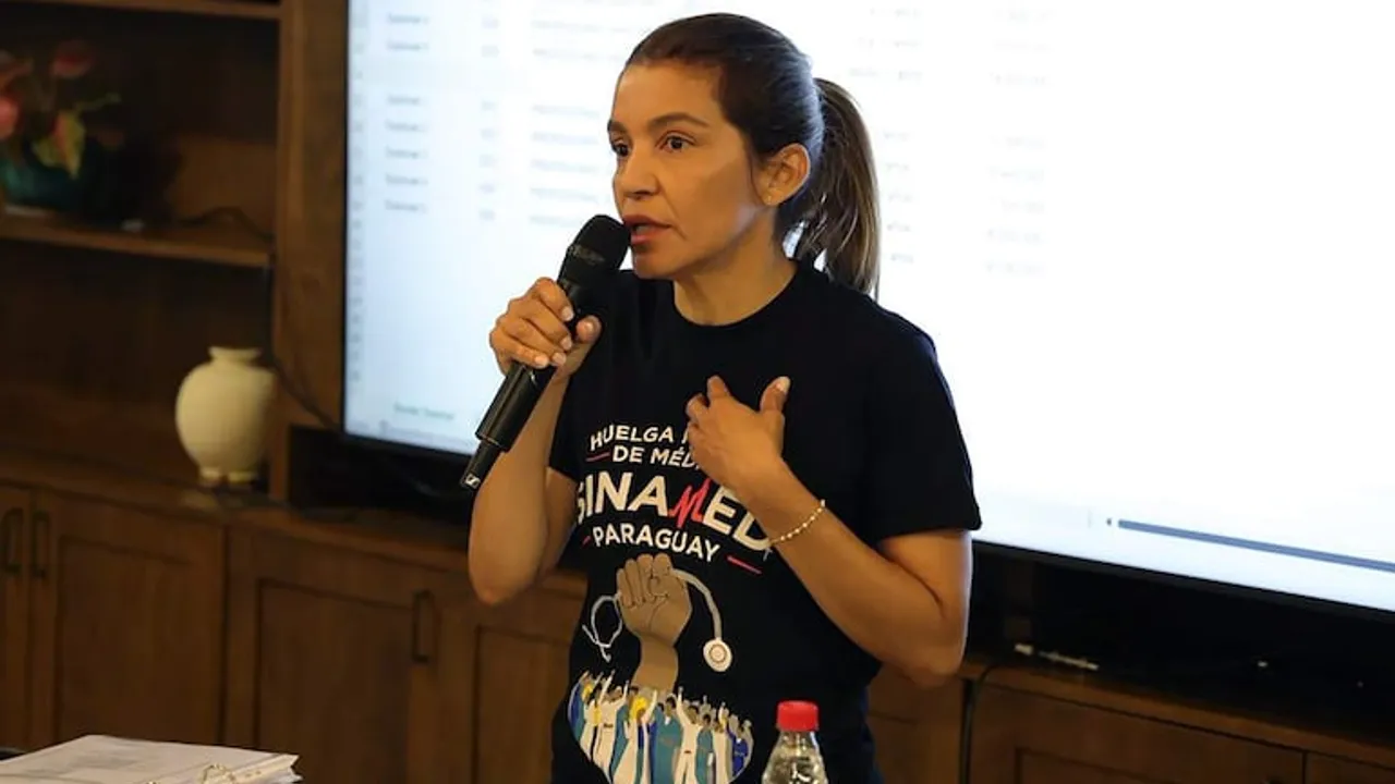 Rossana González habla con un micrófono vistiendo una remera negra del sindicato Sinamed Paraguay.