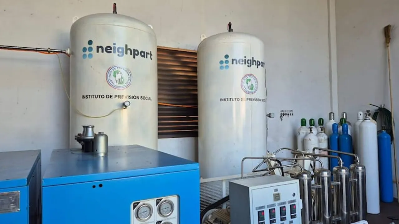 Dos grandes tanques blancos con el logo de Neighpart e IPS junto a equipos azules y balones de oxígeno.