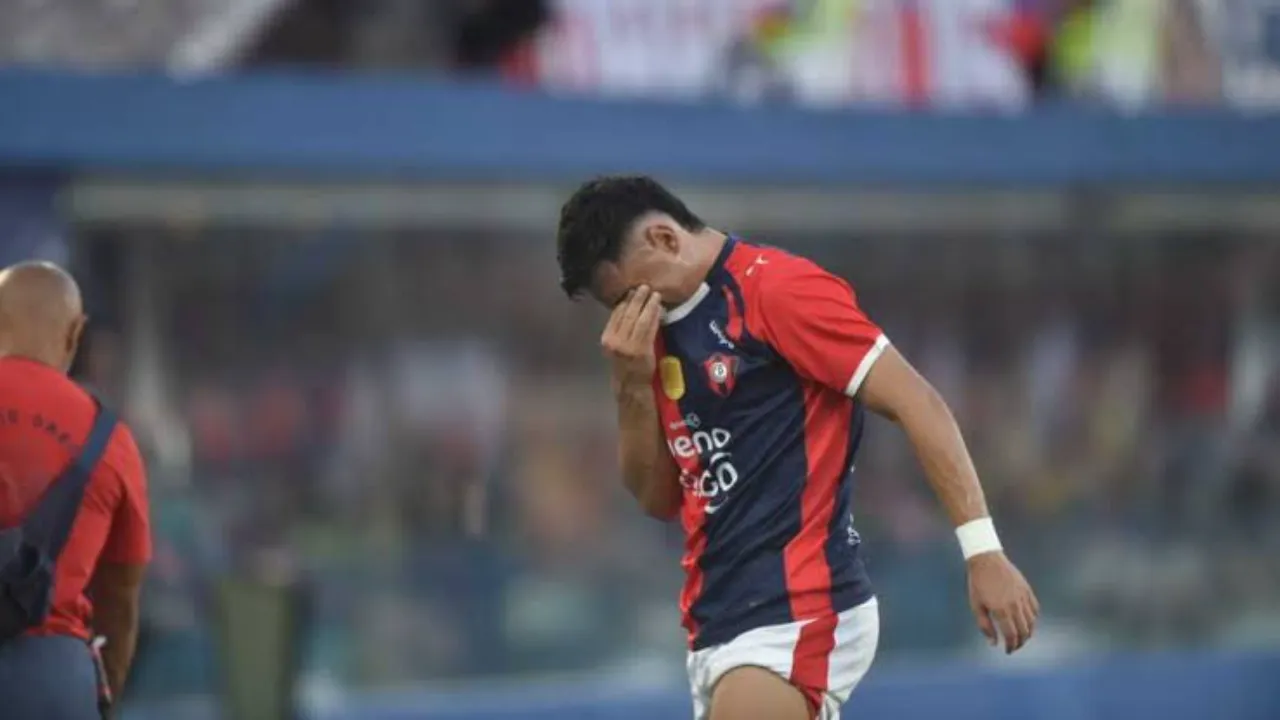 Blas Riveros camina con la camiseta de Cerro Porteño y se cubre el rostro con la mano en la cancha.