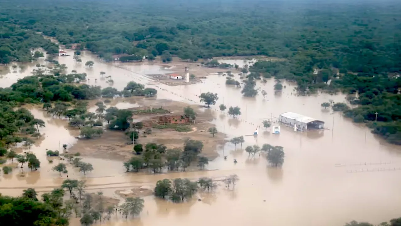 Vista aérea de un área rural inundada con caminos, árboles y construcciones anegados por el agua.