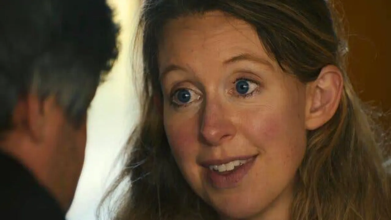 Primer plano de Elizabeth Holmes sonriendo a la cámara con el cabello claro y ojos azules.