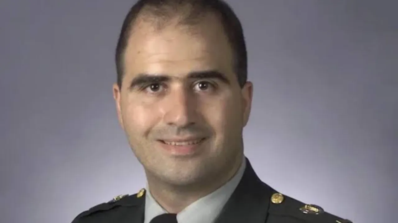 Retrato oficial de Nidal Hasan vistiendo uniforme militar verde del Ejército estadounidense sobre fondo gris