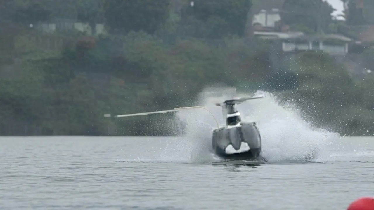 Helicóptero impacta contra el agua y levanta espuma blanca en la superficie de un lago en medio de la neblina.