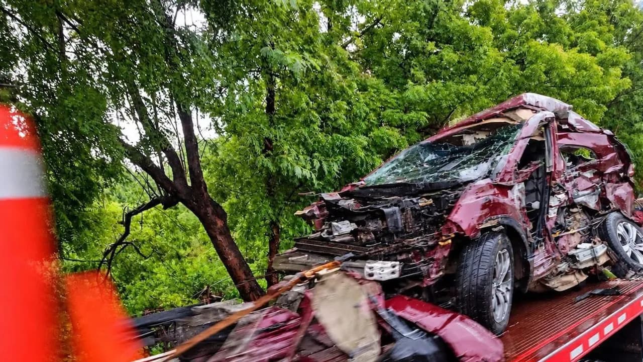 Camioneta particular de color rojo completamente destrozada sobre la plataforma de una grúa tras un choque vial.