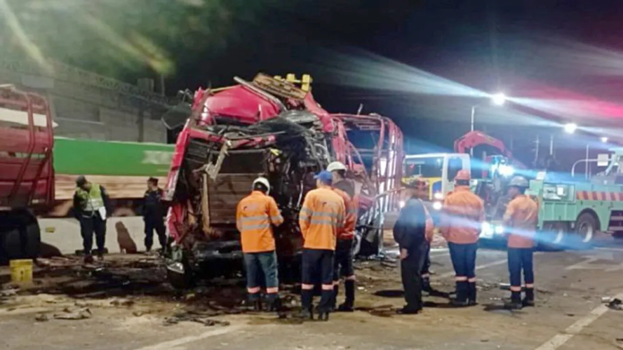 Rescatistas y trabajadores viales observan la cabina destruida de un camión de carga durante la noche en la ruta.