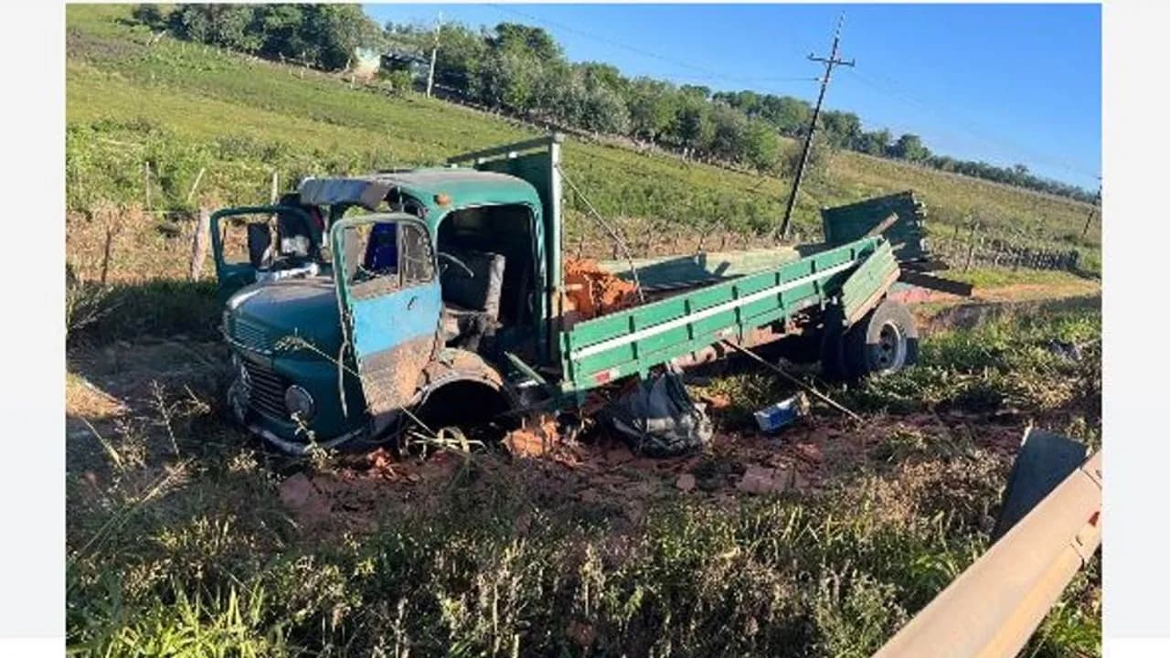 Camión antiguo de color verde volcado al costado de una ruta con la carrocería dañada y escombros esparcidos.