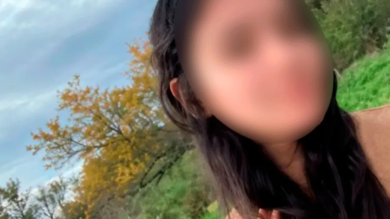 Rostro difuminado de una joven con cabello oscuro sobre un fondo natural con árboles y cielo