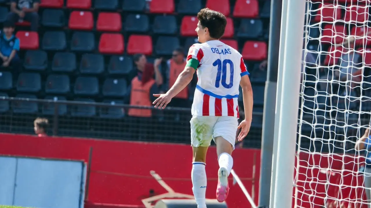 Futbolista con la camiseta de Paraguay vistiendo el dorsal diez festeja un gol de espaldas sobre el césped.