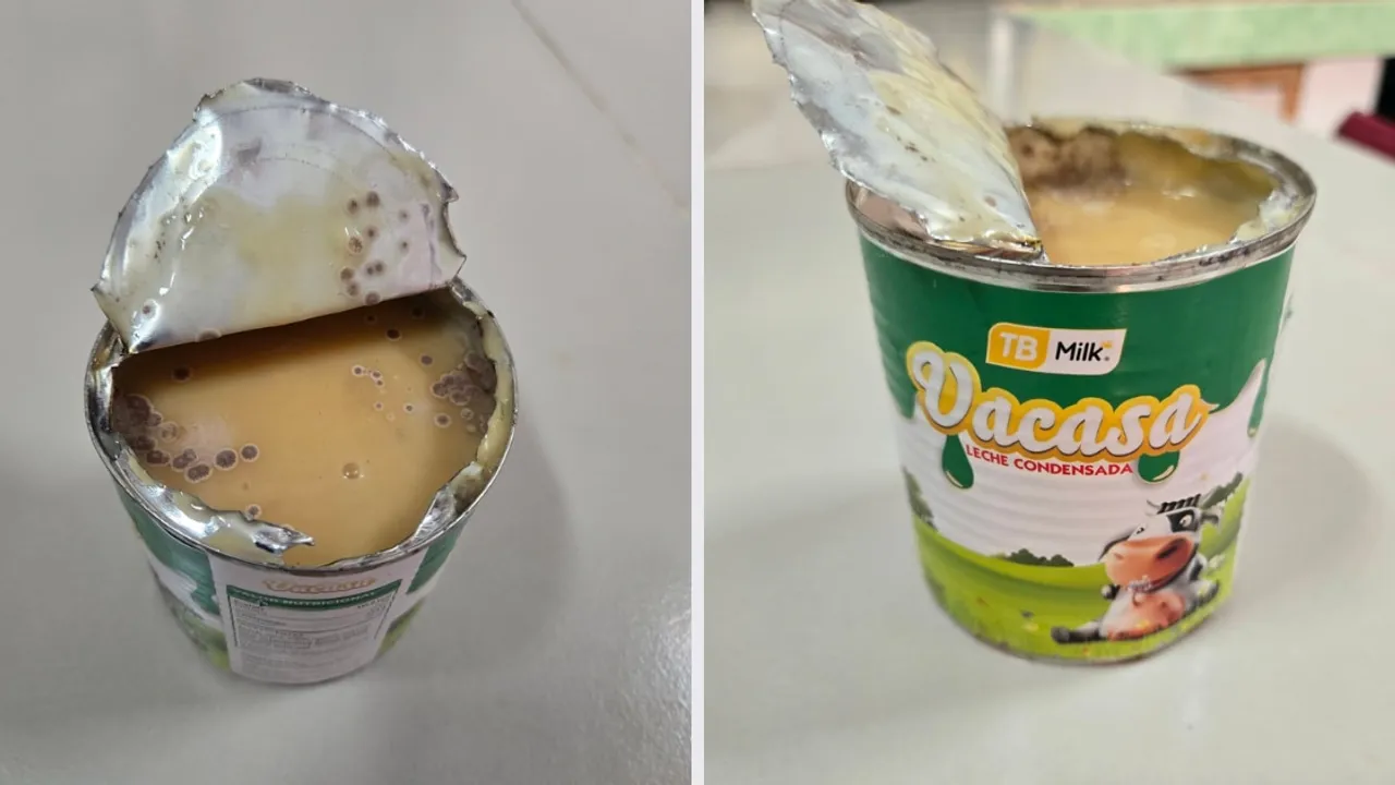 Lata de leche condensada abierta que exhibe manchas oscuras y moho en su superficie sobre un mostrador.