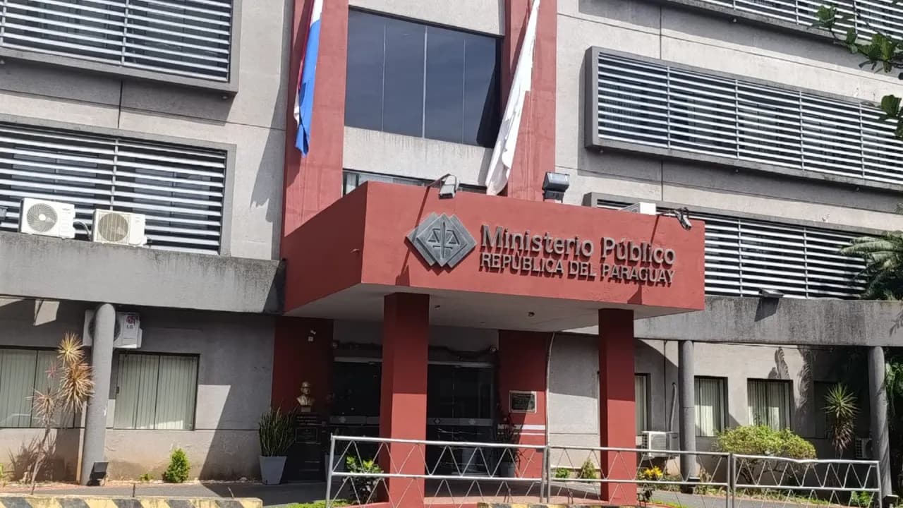 Fachada del edificio del Ministerio Público con entrada techada en color bordó y rejas metálicas al frente.