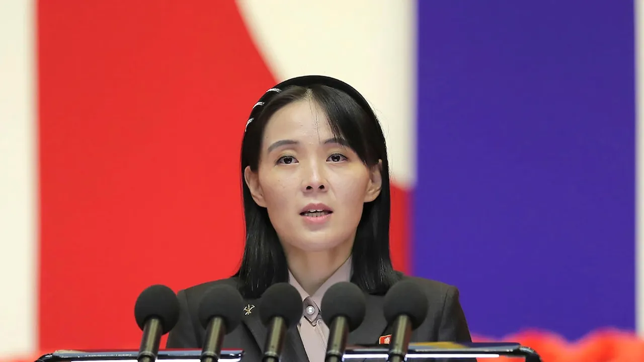 Kim Yo-jong habla frente a micrófonos con una bandera de fondo durante un acto oficial.