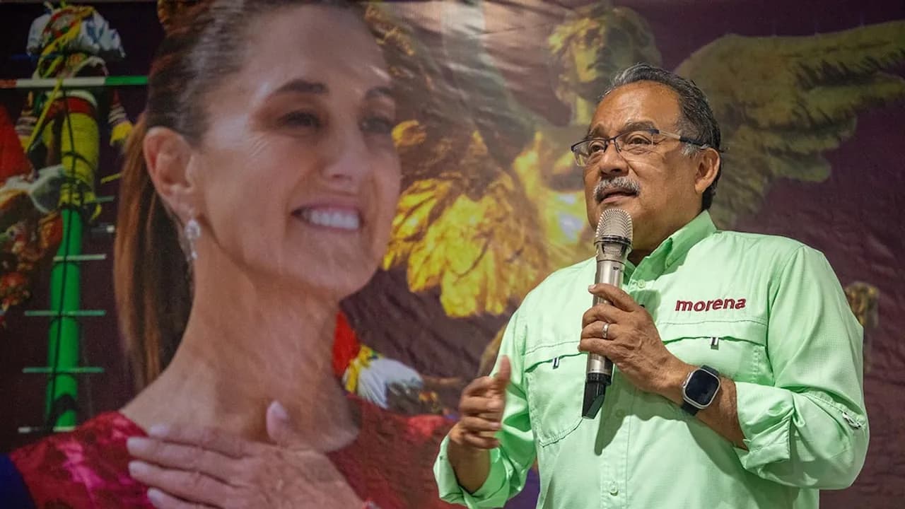 Andrés Mijes habla con micrófono mientras al fondo se proyecta la imagen de la presidenta mexicana Claudia Sheinbaum.
