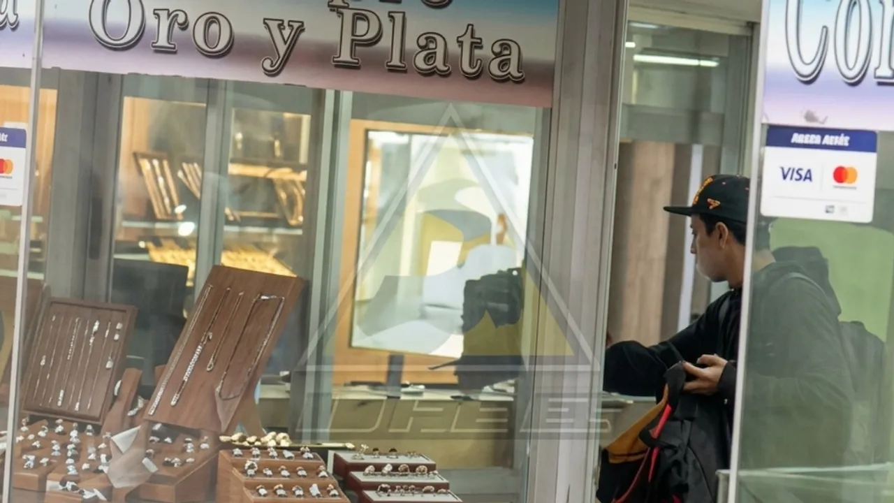 Hombre con gorra y mochila frente al escaparate de una joyería con anillos y cadenas exhibidos.