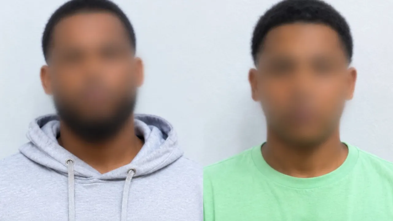 Dos hombres con los rostros difuminados, uno vistiendo un abrigo gris con capucha y el otro una remera verde clara.