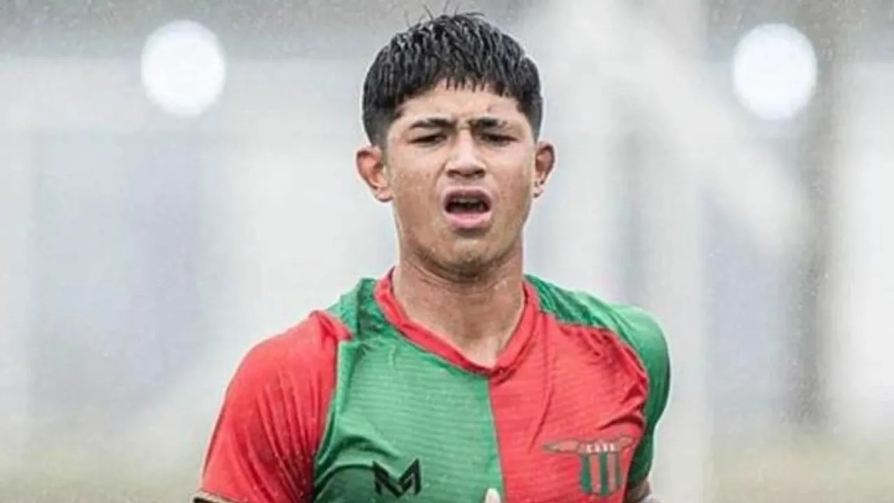 Joven deportista vistiendo una camiseta roja y verde durante un entrenamiento al aire libre.