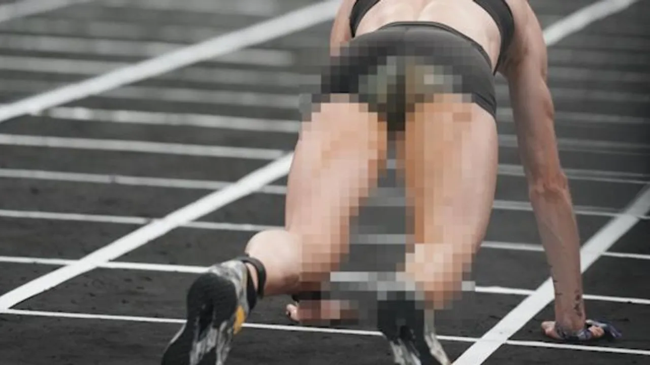 Atleta en posición de carrera sobre una pista con ropa deportiva oscura y parte de la imagen cubierta por píxeles.