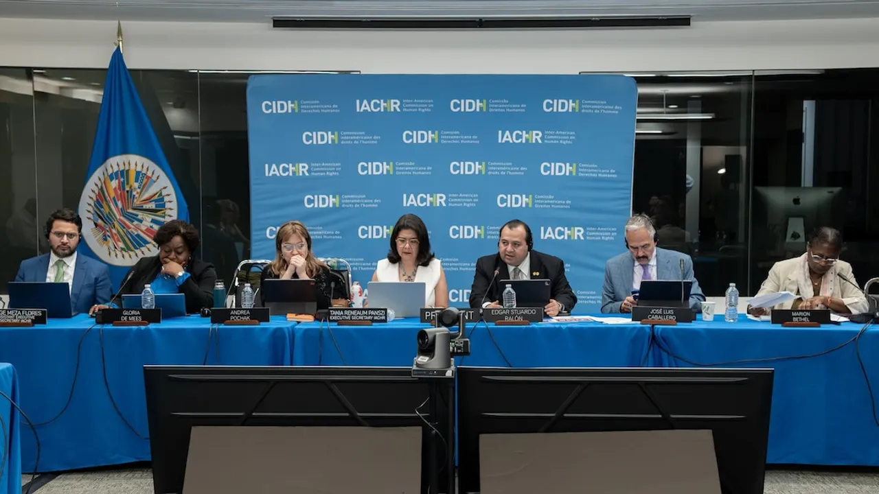 Integrantes de la Comisión Interamericana de Derechos Humanos sentados frente a computadoras durante una sesión formal.