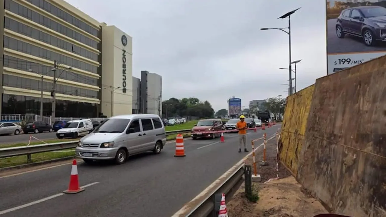 Vehículos circulando sobre media calzada delimitada con conos y un banderillero frente al hotel Bourbon.