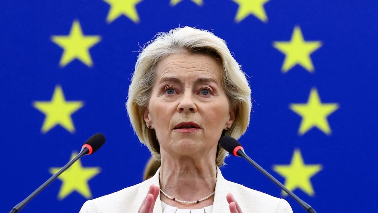 Ursula von der Leyen habla frente a dos micrófonos con una bandera de la Unión Europea detrás.