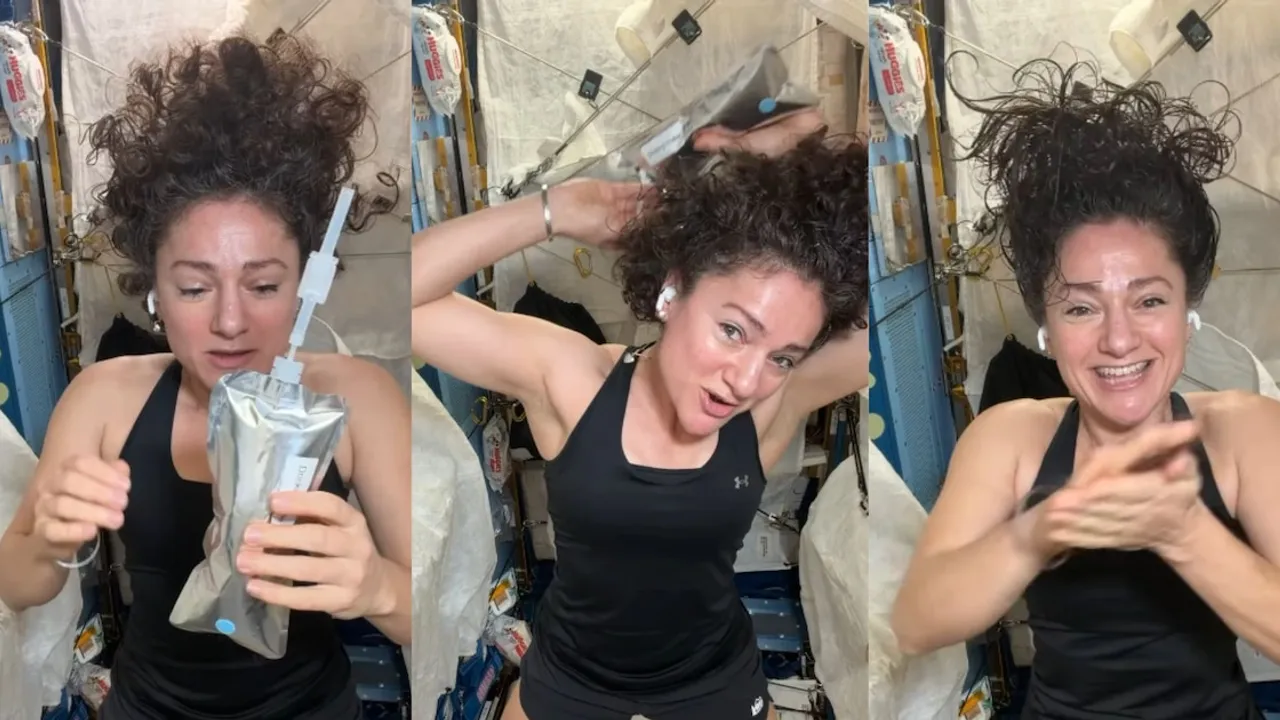 Astronauta en microgravedad aplicándose agua de una bolsa plateada sobre el cabello rizado dentro de la nave