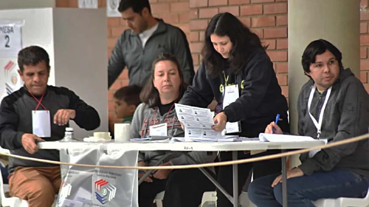 Miembros de mesa electoral clasifican y revisan papeletas de votación durante una jornada cívica.