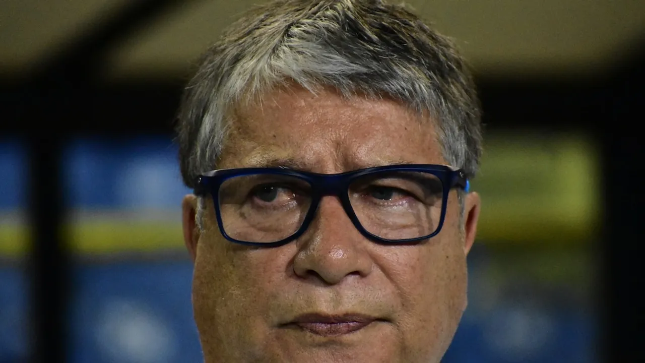 Primer plano de Hernán Darío Gómez con el ceño serio y anteojos de marco oscuro durante un compromiso deportivo.