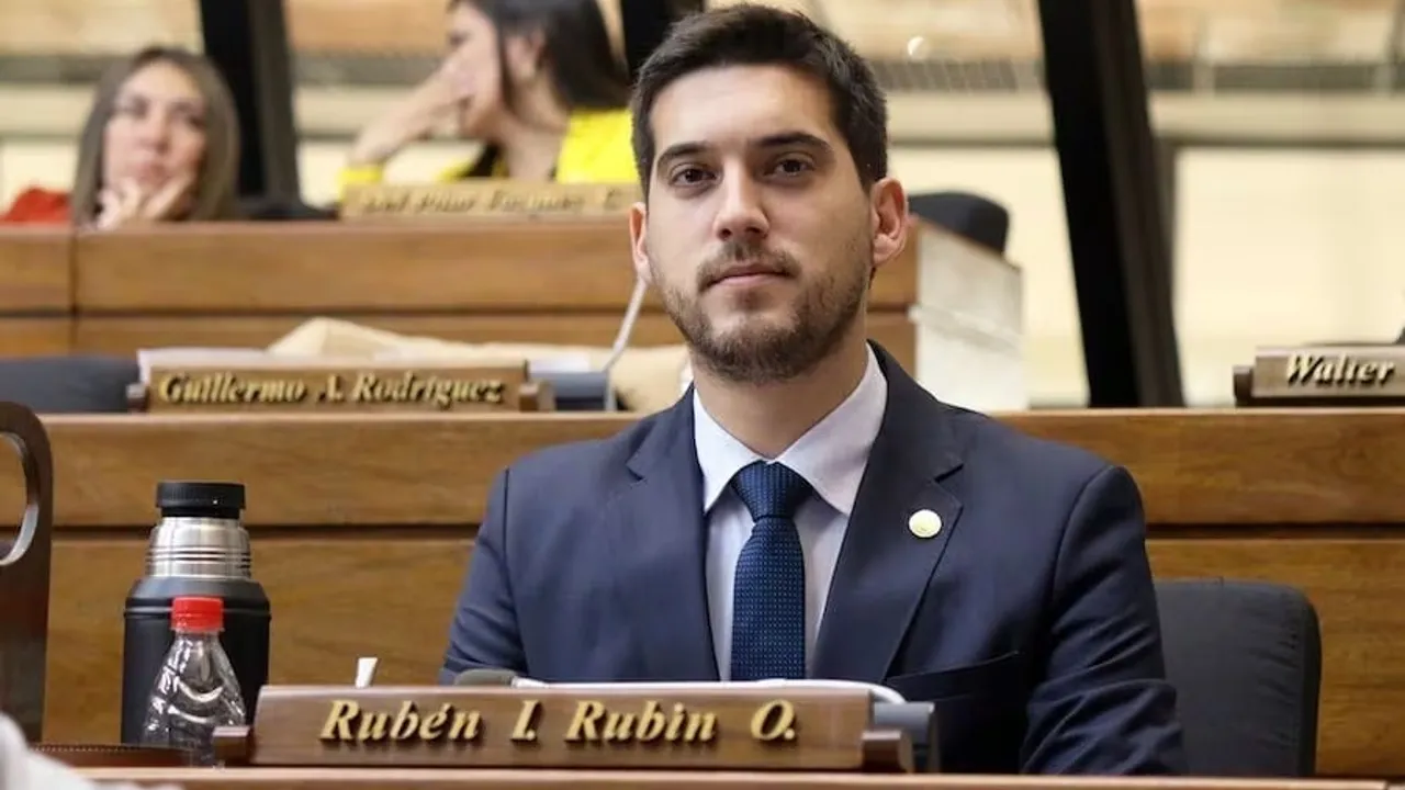 El diputado Rubén Rubín sentado en su banca de la Cámara de Diputados viste traje oscuro y corbata azul durante una sesión.