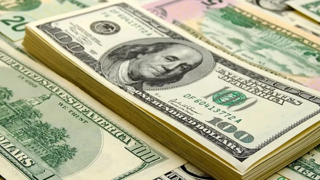 Fajos de billetes de cien dólares estadounidenses apilados en primer plano sobre una mesa.