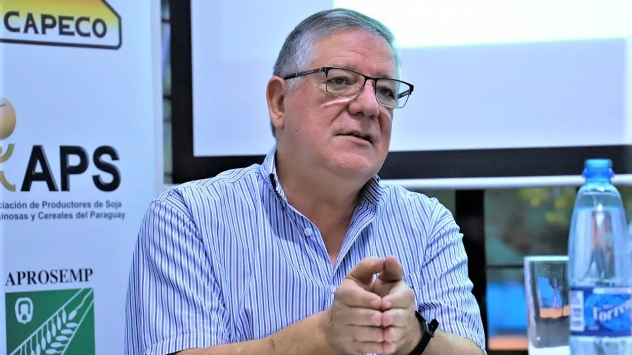 Héctor Cristaldo, titular de la UGP, hablando con las manos entrelazadas en una conferencia frente a pancartas gremiales.
