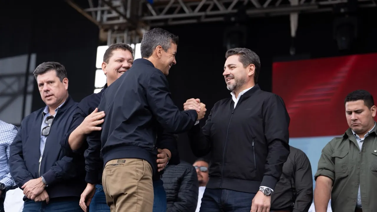 Santiago Peña estrecha la mano de Pedro Alliana sobre un escenario durante un acto político en Asunción