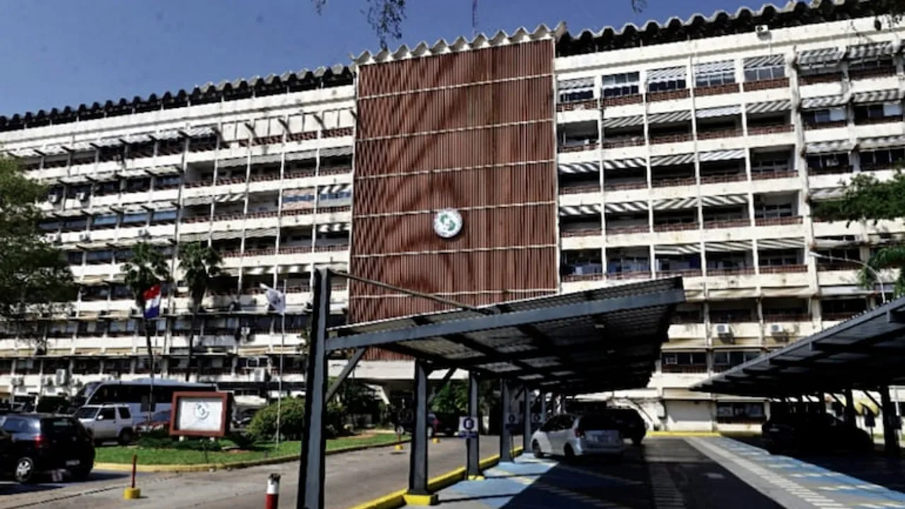 Fachada principal del Hospital Central del Instituto de Previsión Social con su estacionamiento techado al frente.