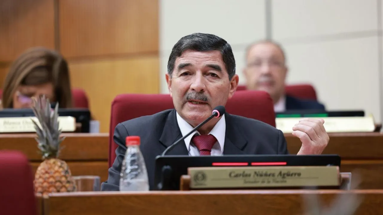 Senador Carlos Núñez Agüero en su banca del Congreso Nacional hablando por micrófono frente a sus colegas.
