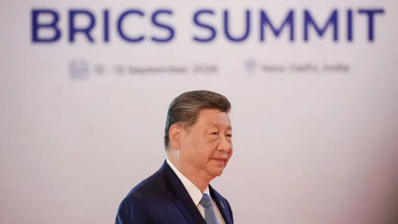 Xi Jinping camina de perfil frente a un panel blanco con las letras del foro internacional BRICS Summit.