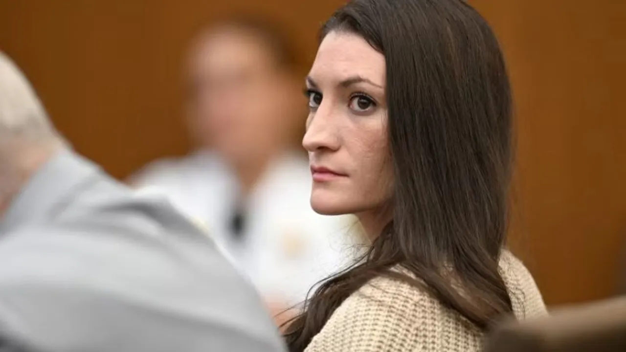 Mujer de cabello largo y oscuro sentada de perfil en una sala judicial mirando hacia adelante con seriedad.