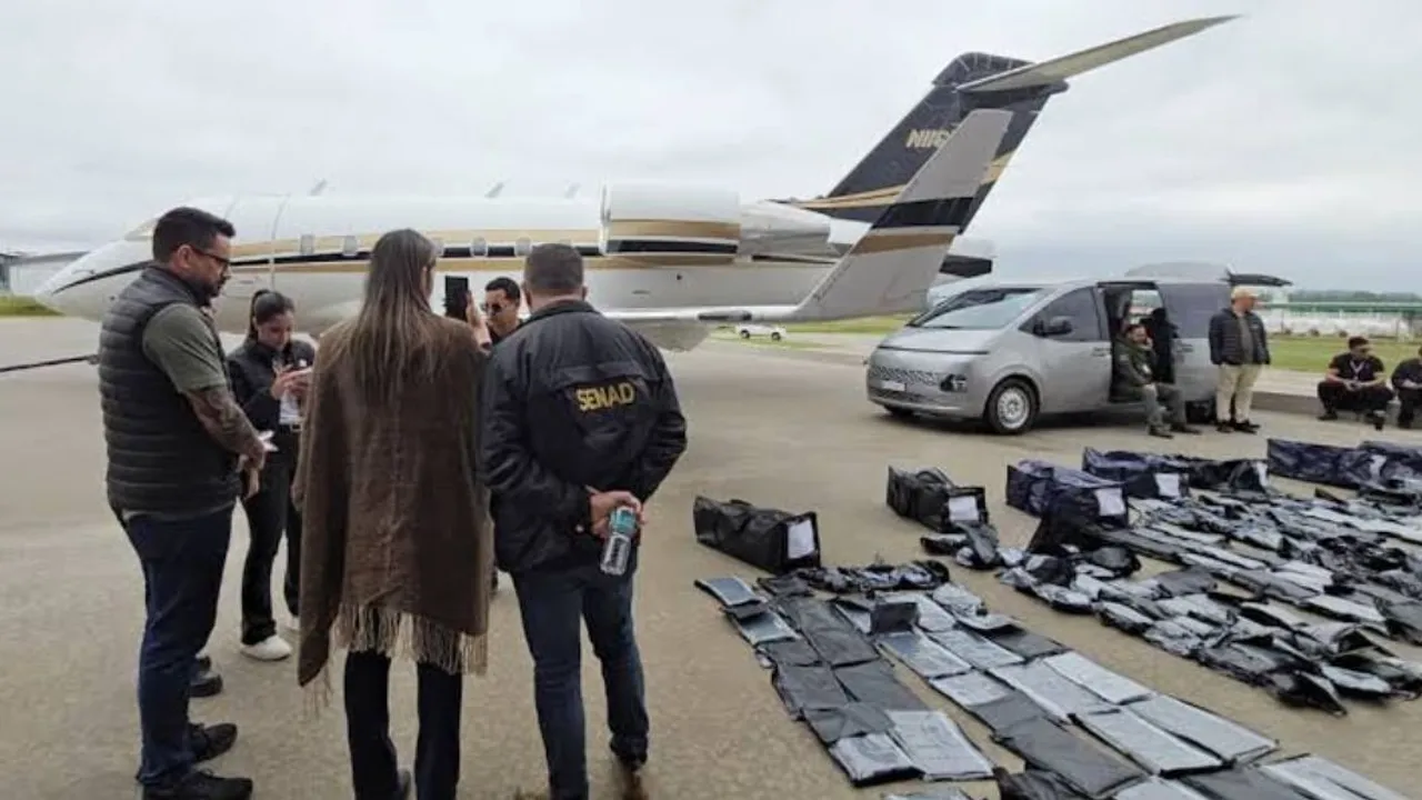 Agentes de la Senad verifican paquetes negros incautados frente a un avión ejecutivo privado en una pista aérea.