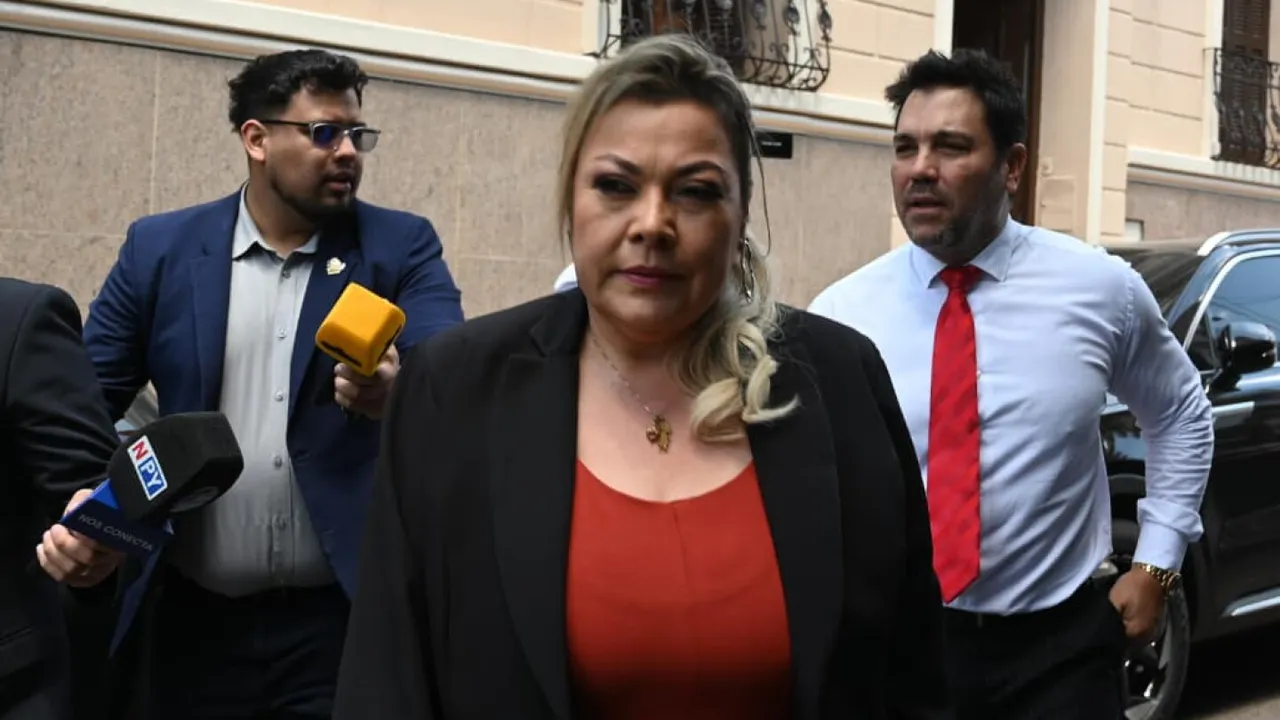 Zenaida Delgado camina en Asunción acompañada de su abogado Óscar Tuma mientras reporteros acercan micrófonos.