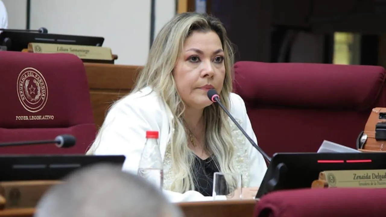Senadora Zenaida Delgado sentada en su banca de la Cámara de Senadores de Paraguay frente a un micrófono.