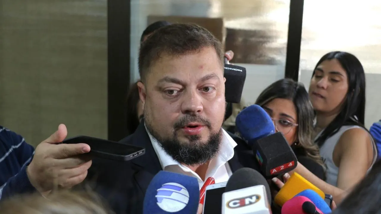 Colym Soroka habla frente a micrófonos y teléfonos de periodistas que cubren la actividad parlamentaria