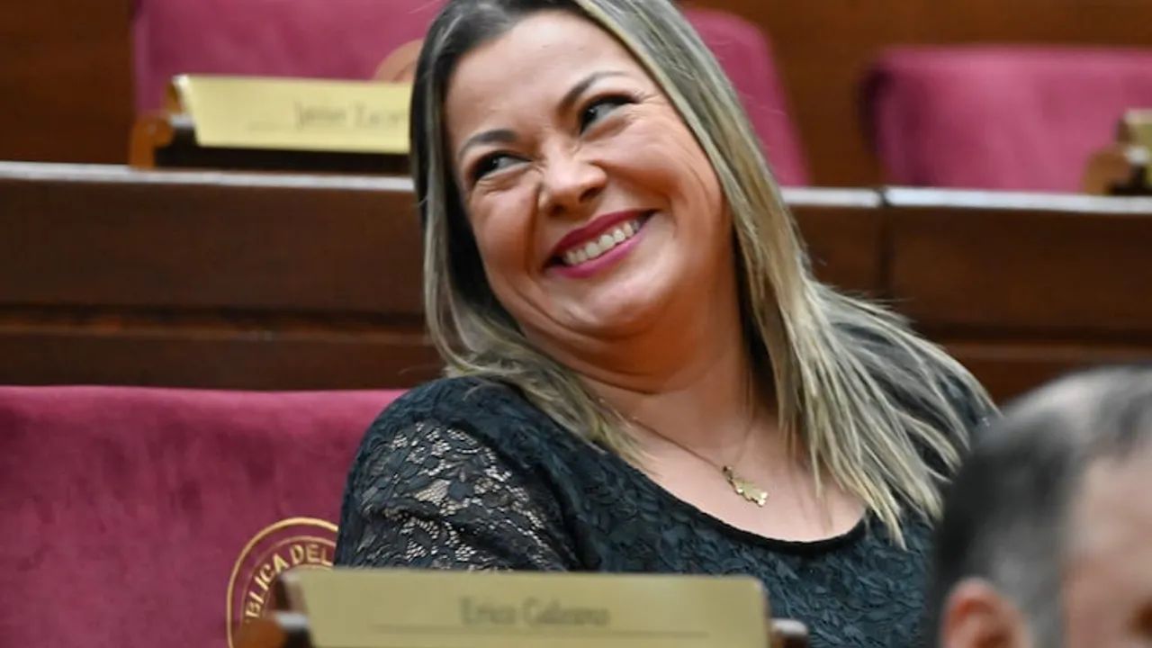 Mujer sonriente con blusa negra de encaje sentada en una curul del Congreso paraguayo.