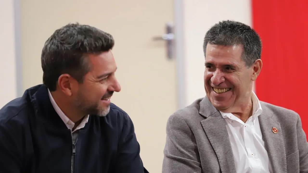Pedro Alliana y Horacio Cartes conversan sonrientes en un salón institucional con vestimenta formal.