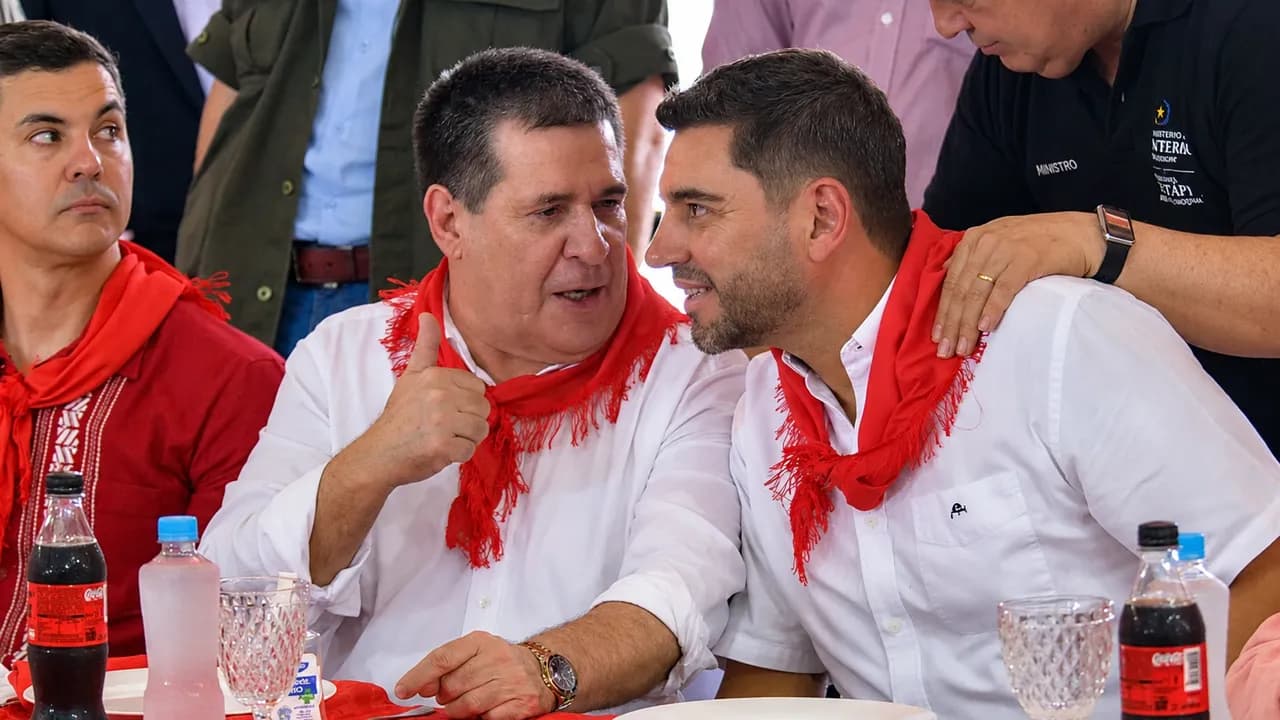 Santiago Peña, Horacio Cartes y Pedro Alliana conversan sentados en una mesa usando pañuelos rojos republicanos.