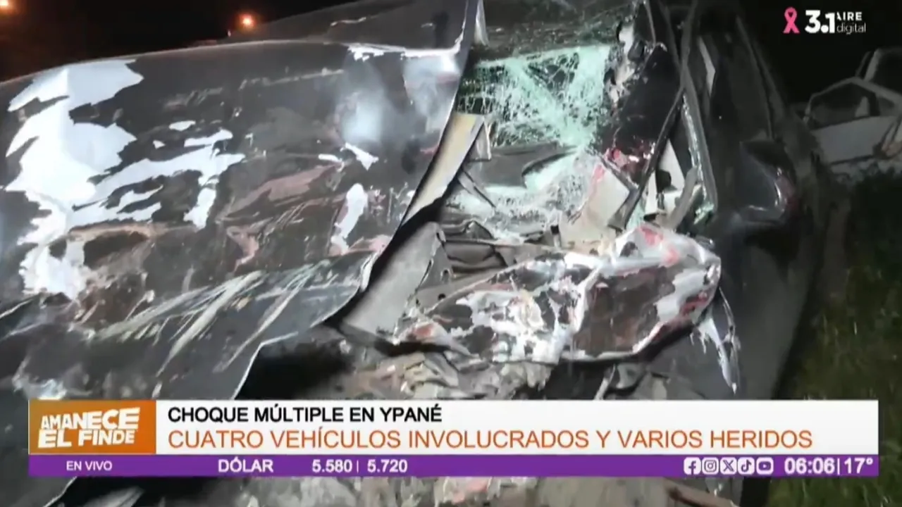 Vehículo de color oscuro con la parte frontal y el capó completamente destrozados tras una colisión vial nocturna.