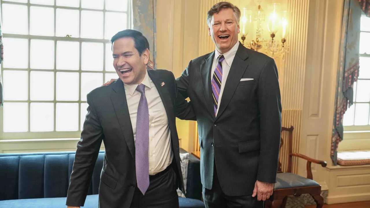 Marco Rubio y Christopher Landau ríen juntos en una elegante sala vestidos con traje formal y corbata.