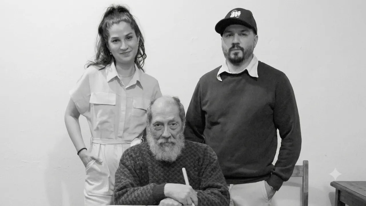 Retrato en blanco y negro de tres bateristas, dos de pie y un hombre mayor con barba sentado