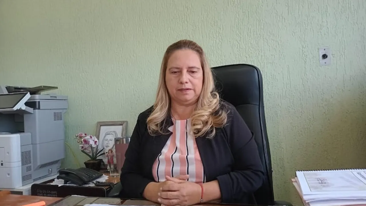 Mujer sentada frente a un escritorio de oficina con las manos entrelazadas junto a documentos